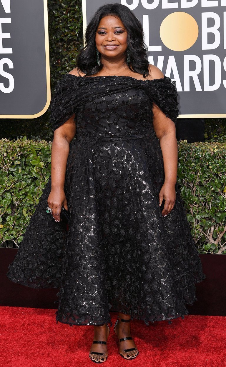 in an off-the-shoulder embellished black tea-length Christian Siriano dress, with black Tamara Mellon sandals and Lorraine Schwartz drop earrings.